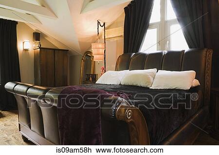 Stock Image - Master bedroom with sleigh bed in luxury home. Fotosearch