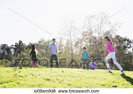 Mature couple and children playing soccer in park View Large Photo Image Stock Photo - Mature couple and children playing soccer in park. Fotosearch