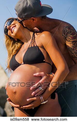 Mature man embracing and kissing pregnant wife at beach View Large Photo Image Stock Photo - Mature man embracing and kissing pregnant wife at beach. Fotosearch