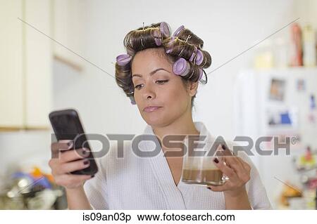 Mid adult woman wearing hair rollers and reading text message on smartphone View Large Photo Image Stock Photography - Mid adult woman wearing hair rollers and reading text message on smartphone. Fotosearch