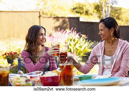 Mother and daughter toasting in garden View Large Photo Image Stock Photograph - Mother and daughter toasting in garden. Fotosearch