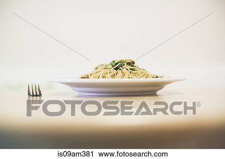 Stock Image - Noodle meal on table with fork. Fotosearch