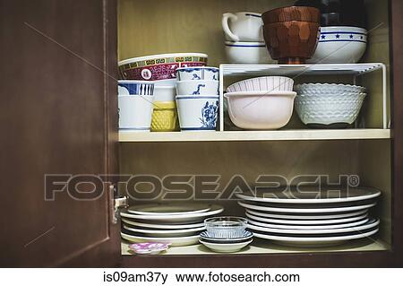 Open cupboard displaying crockery View Large Photo Image Stock Photo - Open cupboard displaying crockery. Fotosearch