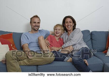 Parents with son sitting on sofa View Large Photo Image Stock Photo - Parents with son sitting on sofa. Fotosearch