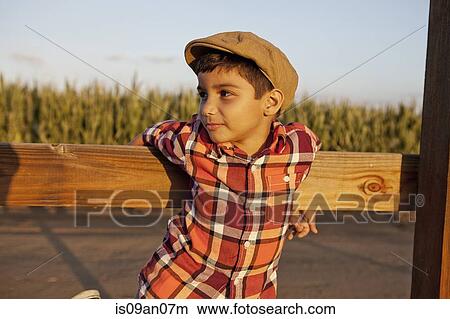 Portrait of boy holding onto wooden fence View Large Photo Image Picture - Portrait of boy holding onto wooden fence. Fotosearch