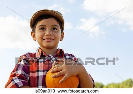 Portrait of boy holding pumpkin in pumpkin field View Large Photo Image Stock Image - Portrait of boy holding pumpkin in pumpkin field. Fotosearch