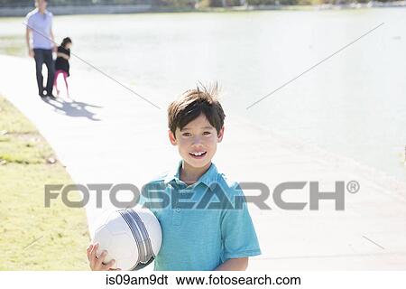 Portrait of boy with ball in park View Large Photo Image Stock Photograph - Portrait of boy with ball in park. Fotosearch