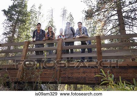 Stock Photo - "Portrait of five young adult friends on wooden bridge in forest, Los Angeles, California, USA". Fotosearch