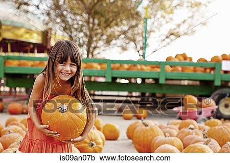 Portrait of girl carrying pumpkin in farmyard View Large Photo Image Stock Image - Portrait of girl carrying pumpkin in farmyard. Fotosearch