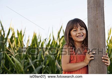 Portrait of girl holding onto field fencepost View Large Photo Image Stock Image - Portrait of girl holding onto field fencepost. Fotosearch