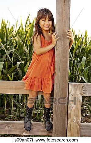 Portrait of girl standing and holding onto field fence View Large Photo Image Stock Image - Portrait of girl standing and holding onto field fence. Fotosearch