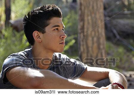 Stock Image - "Portrait of young man in forest, Los Angeles, California, USA". Fotosearch