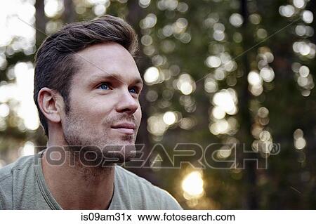 Stock Photo - "Portrait of young man in forest, Los Angeles, California, USA". Fotosearch