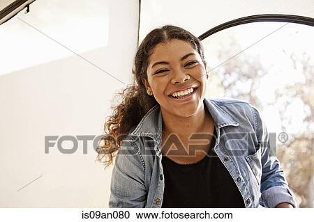 Stock Image - Portrait of young woman in tent entrance. Fotosearch