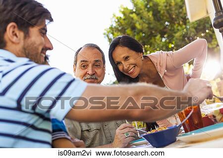Three generation family dining in garden View Large Photo Image Stock Image - Three generation family dining in garden. Fotosearch