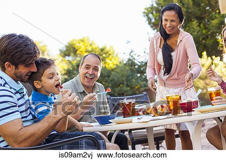 Three generation family dining in garden View Large Photo Image Stock Image - Three generation family dining in garden. Fotosearch