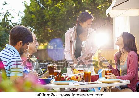 Three generation family dining in garden View Large Photo Image Stock Image - Three generation family dining in garden. Fotosearch