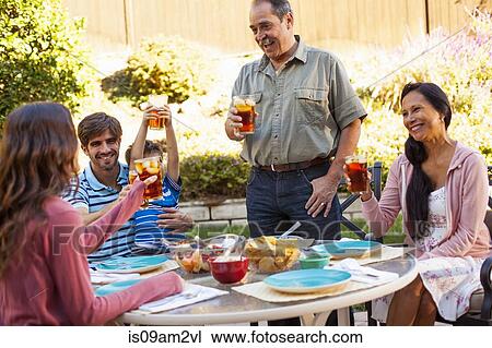 Three generation family dining in garden View Large Photo Image Stock Image - Three generation family dining in garden. Fotosearch