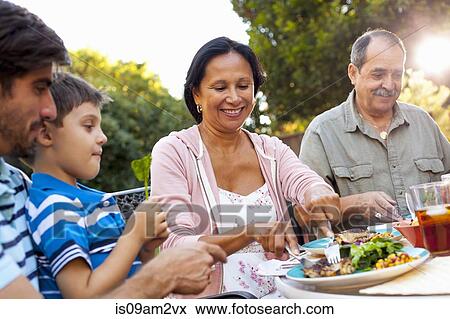 Three generation family dining in garden View Large Photo Image Stock Photo - Three generation family dining in garden. Fotosearch