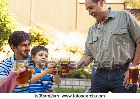 Picture - Three generation family toasting in garden. Fotosearch