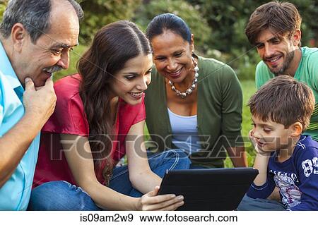 Three generation family using digital tablet in garden View Large Photo Image Stock Photo - Three generation family using digital tablet in garden. Fotosearch