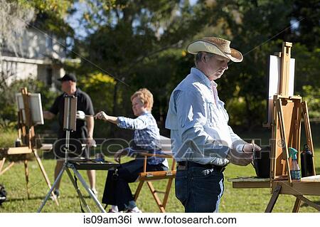 Stock Image - "Three plein-air painters in Albin Polasek Museum and Sculpture Garden, Winter Park, Florida, USA". Fotosearch