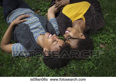 Two mature female friends lying on park grass View Large Photo Image Stock Photograph - Two mature female friends lying on park grass. Fotosearch