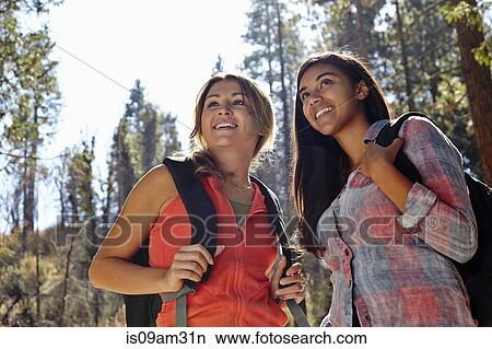 Picture - "Two young adult females hiking in forest, Los Angeles, California, USA". Fotosearch