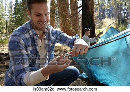 "Two young men erecting tent in forest, Los Angeles, California, USA" View Large Photo Image Stock Image - "Two young men erecting tent in forest, Los Angeles, California, USA". Fotosearch