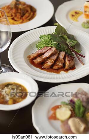 Variety of plates surrounding sliced meat and lettuce garnish View Large Photo Image Stock Image - Variety of plates surrounding sliced meat and lettuce garnish. Fotosearch
