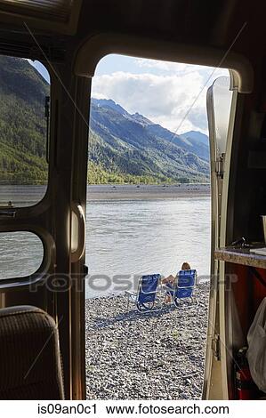 "View from camper van doorway of mid adult woman sitting by lake, Palmer, Alaska, USA" View Large Photo Image Stock Image - "View from camper van doorway of mid adult woman sitting by lake, Palmer, Alaska, USA". Fotosearch