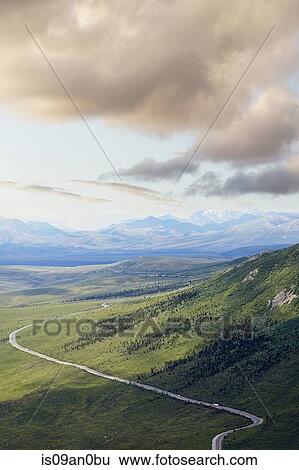 Stock Photograph - "View of distant highway and mountains, Denali National Park, Alaska, USA". Fotosearch