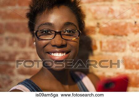 Woman using smartphone by brick wall View Large Photo Image Stock Image - Woman using smartphone by brick wall. Fotosearch