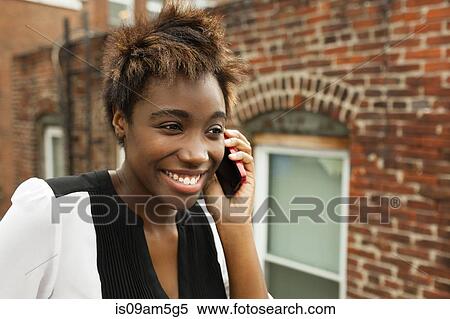 Woman using smartphone by brick wall View Large Photo Image Stock Photography - Woman using smartphone by brick wall. Fotosearch