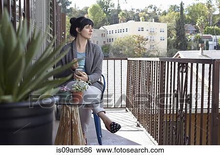 Woman using smartphone on balcony View Large Photo Image Stock Photograph - Woman using smartphone on balcony. Fotosearch