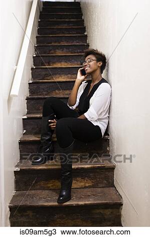 Woman using smartphone on staircase View Large Photo Image Stock Image - Woman using smartphone on staircase. Fotosearch