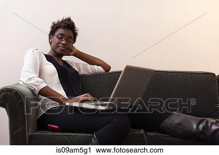 Woman working at laptop on sofa View Large Photo Image Stock Image - Woman working at laptop on sofa. Fotosearch