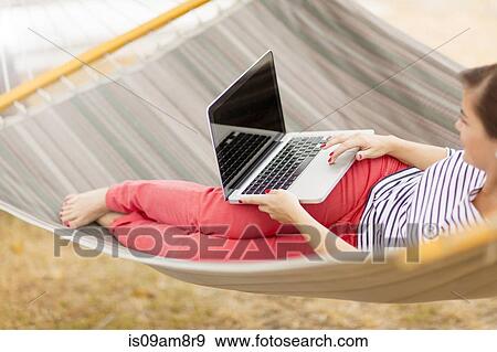 Women using laptop on hammock View Large Photo Image Stock Photo - Women using laptop on hammock. Fotosearch