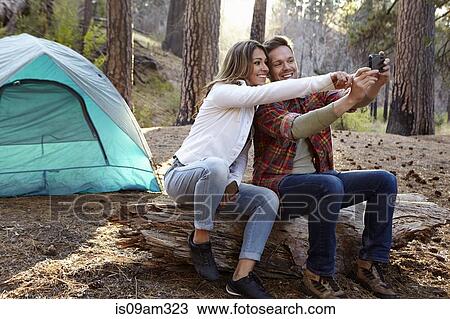 "Young camping couple taking smartphone selfie in forest, Los Angeles, California, USA" View Large Photo Image Stock Image - "Young camping couple taking smartphone selfie in forest, Los Angeles, California, USA". Fotosearch