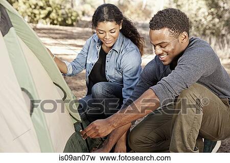 Young couple in forest putting up tent View Large Photo Image Stock Photo - Young couple in forest putting up tent. Fotosearch