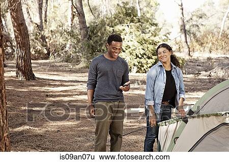 Young couple preparing tent to camp in forest View Large Photo Image Stock Photograph - Young couple preparing tent to camp in forest. Fotosearch