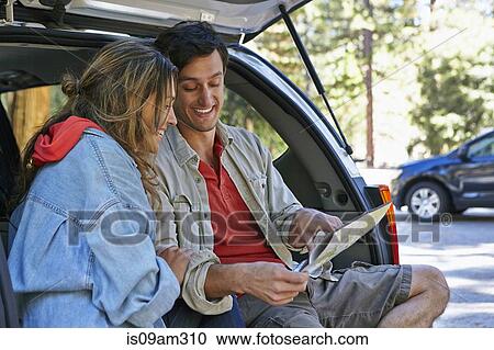 "Young couple sitting on car boot looking at map, Los Angeles, California, USA" View Large Photo Image Stock Image - "Young couple sitting on car boot looking at map, Los Angeles, California, USA". Fotosearch