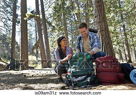 "Young couple unpacking camping rucksack in forest, Los Angeles, California, USA" View Large Photo Image Stock Photo - "Young couple unpacking camping rucksack in forest, Los Angeles, California, USA". Fotosearch