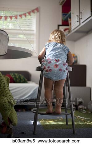 "Young girl balancing on stool, rear view" View Large Photo Image Stock Photography - "Young girl balancing on stool, rear view". Fotosearch
