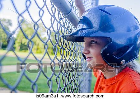 "Young girl wearing baseball kit, looking through fence" View Large Photo Image Stock Image - "Young girl wearing baseball kit, looking through fence". Fotosearch