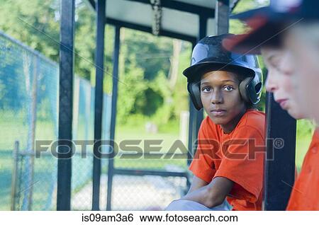 Stock Photograph - Young male baseball players waiting to play. Fotosearch