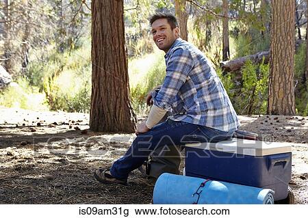 "Young man in forest sitting on cool box, Los Angeles, California, USA" View Large Photo Image Stock Image - "Young man in forest sitting on cool box, Los Angeles, California, USA". Fotosearch