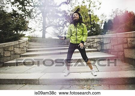 "Young woman, outdoors, listening to music and dancing" View Large Photo Image Stock Image - "Young woman, outdoors, listening to music and dancing". Fotosearch