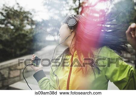 "Young woman, outdoors, listening to music and dancing" View Large Photo Image Stock Image - "Young woman, outdoors, listening to music and dancing". Fotosearch