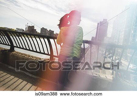"Young woman standing on bridge, doing stretches, rear view" View Large Photo Image Stock Photo - "Young woman standing on bridge, doing stretches, rear view". Fotosearch